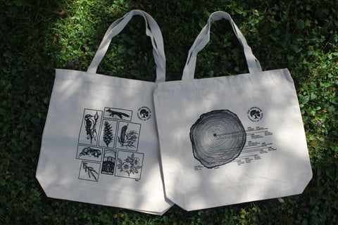 Both Arboretum tote bags pictured together with the naturalist sketches and tree ring designs. 