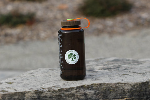 Five cm (Two inch) round, white sticker with green print which says "The Arboretum, University of Guelph" and has the Arboretum's logo in the middle on a water bottle