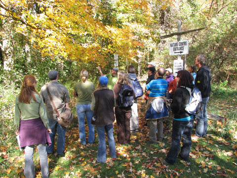 a group of people listening to an instructor speak to them outdoors